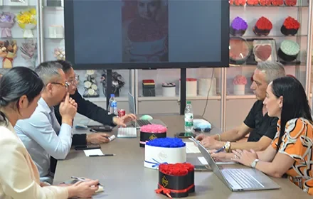 UKIQUEEN business meeting with global clients surrounded by luxury preserved rose gift boxes in pink and blue.